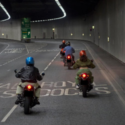 Four Royal Enfield Hunter 350 bikes riding through a tunnel